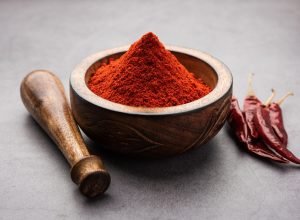 Red Chilli or Lal Mirchi or mirch with Powder in a bowl or mortar over moody background, selective focus